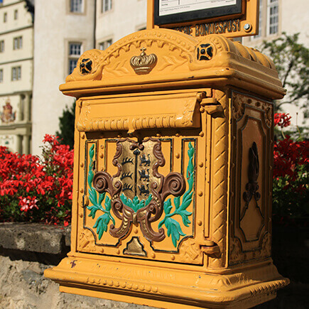 Historischer gelber Briefkasten beim Deutschordensplatz in Bad Mergentheim.