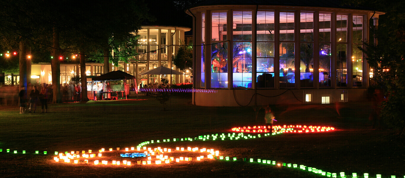 Nachtaufnahme des Kurparkfests in Bad Mergentheim mit bunten Kerzen zur Beleuchtung des Kurparks.